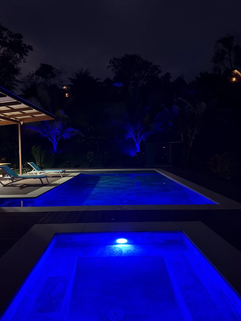 Illuminated blue pool and jacuzzi at night