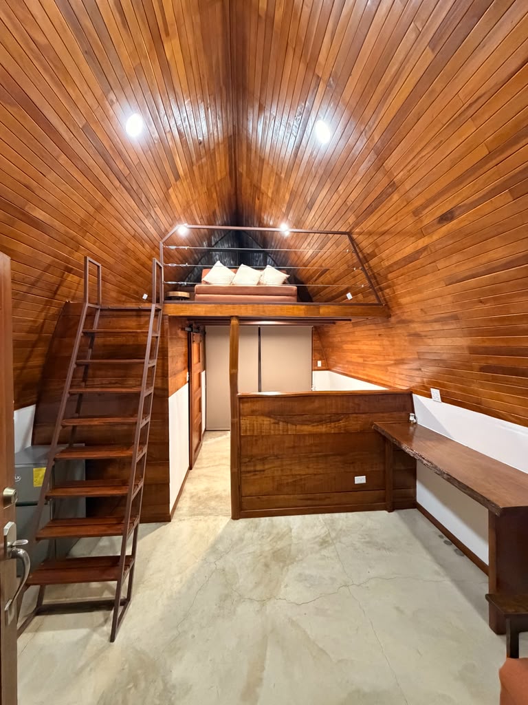 Bungalow interior with desk, mini-fridge and loft mezzanine