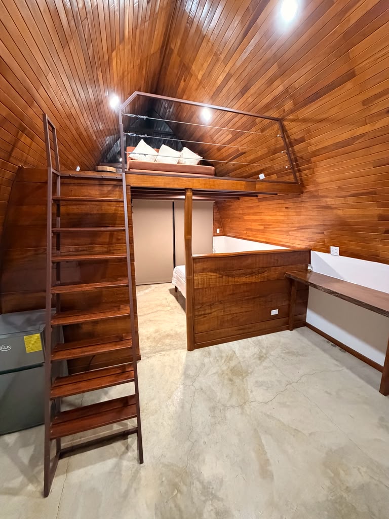 Wooden staircase leading to the loft bed inside a bungalow
